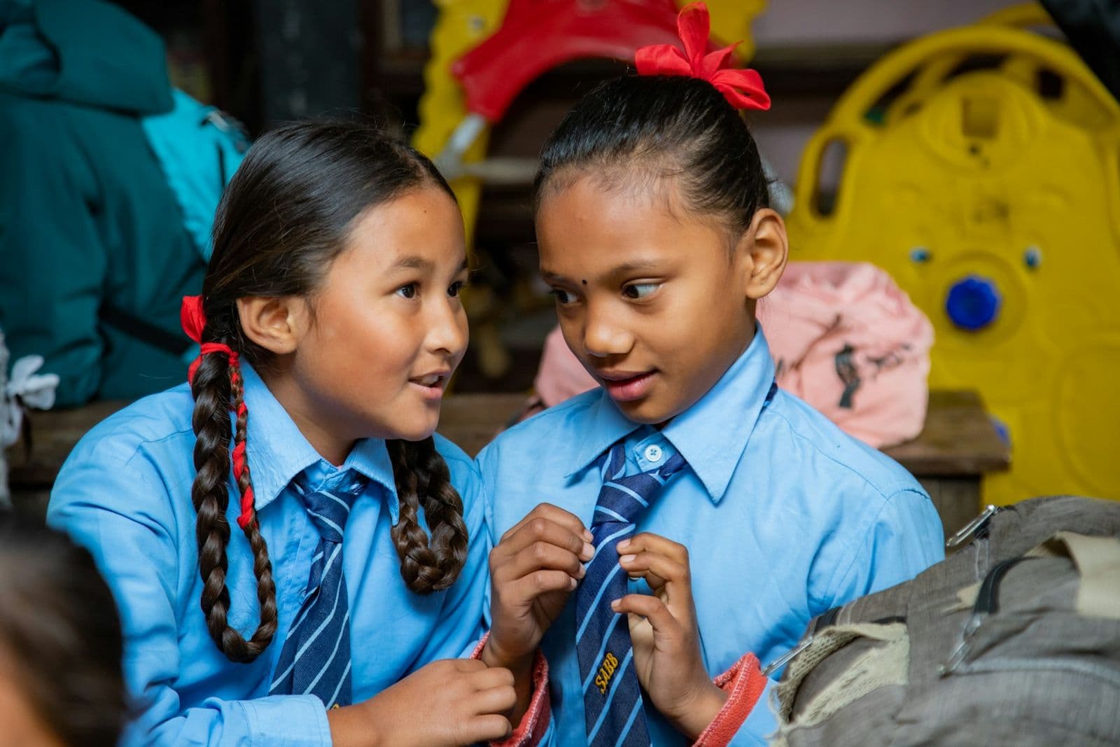 Two Nepali schoolgirls in uniform chatting