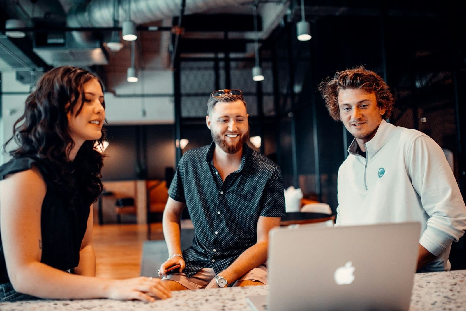 Small team gathered around a laptop